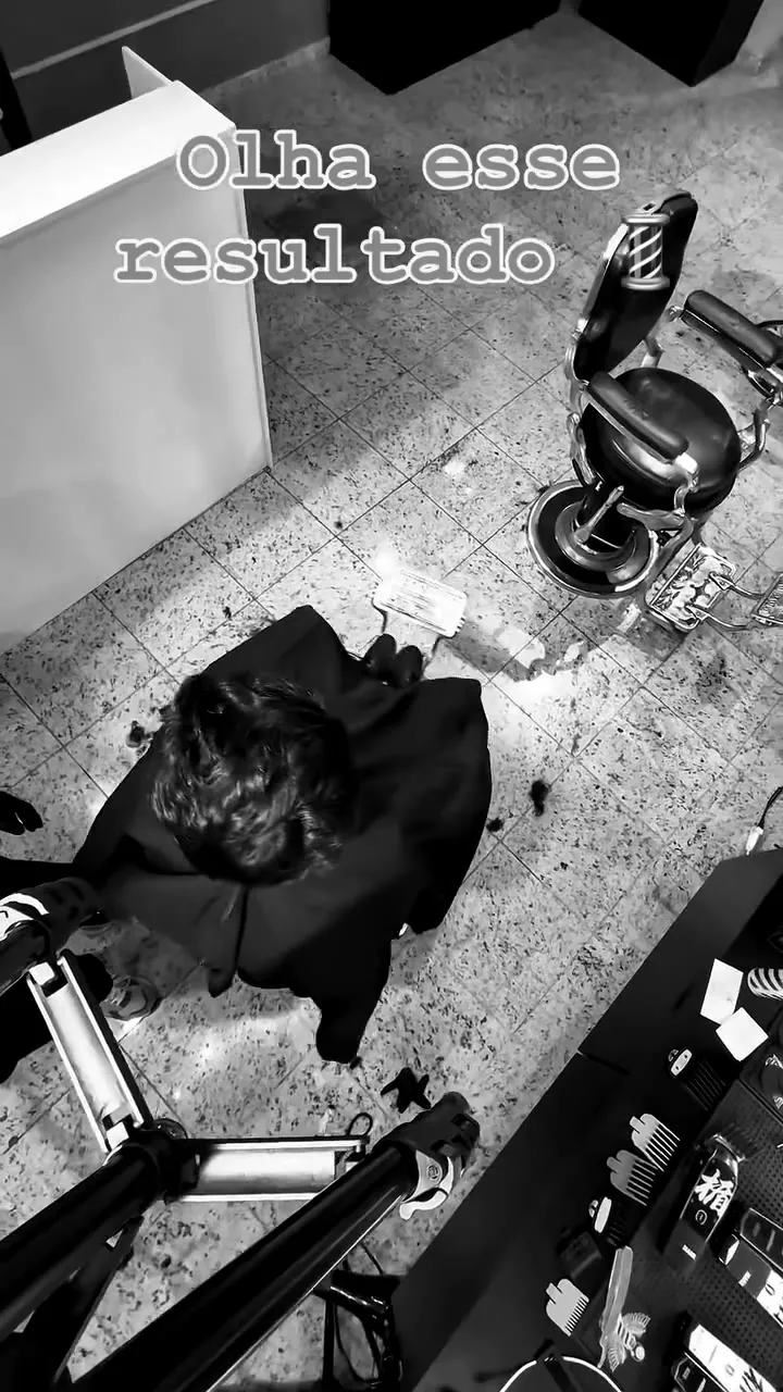 Cliente sendo atendido na cadeira da barbearia