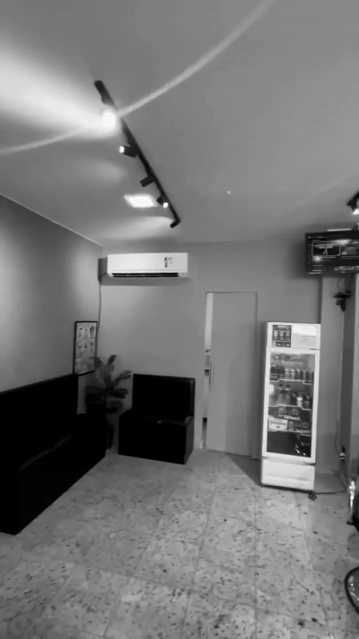 Sala de espera da Barbearia Carvalho com sofás e geladeira